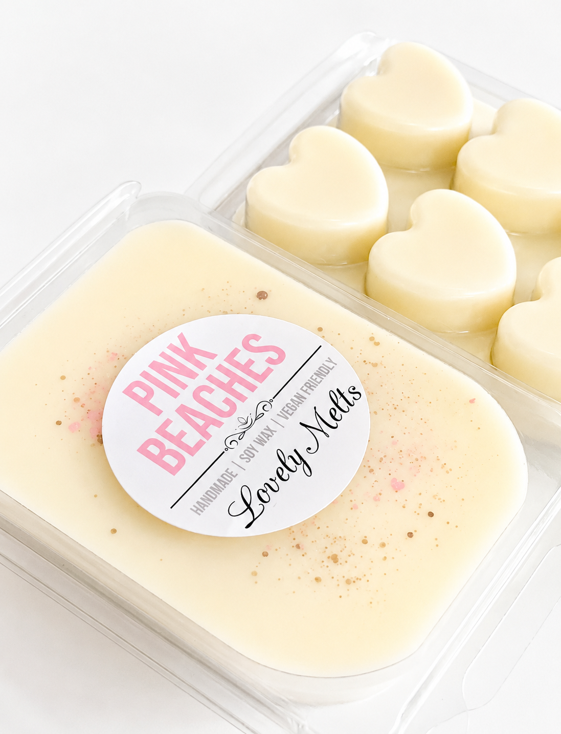 Heart-shaped WAX MELTS in a clear container with a 'Pink Beaches' label.