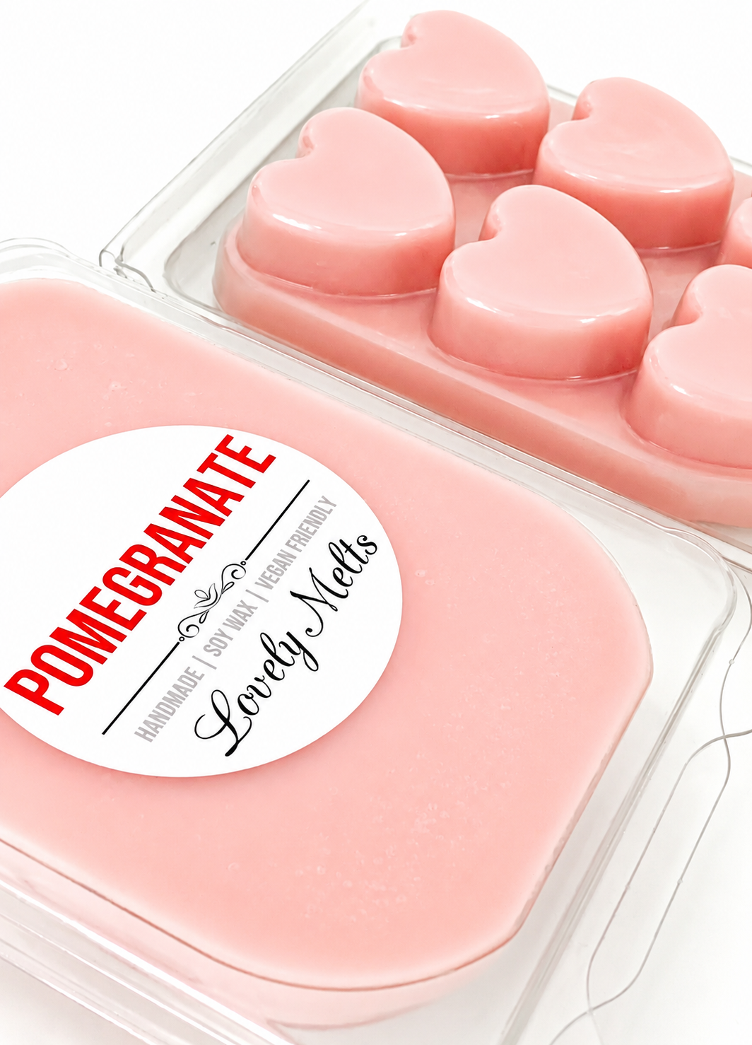 Pink heart-shaped wax melts in a container with a 'Pomegranate' label.