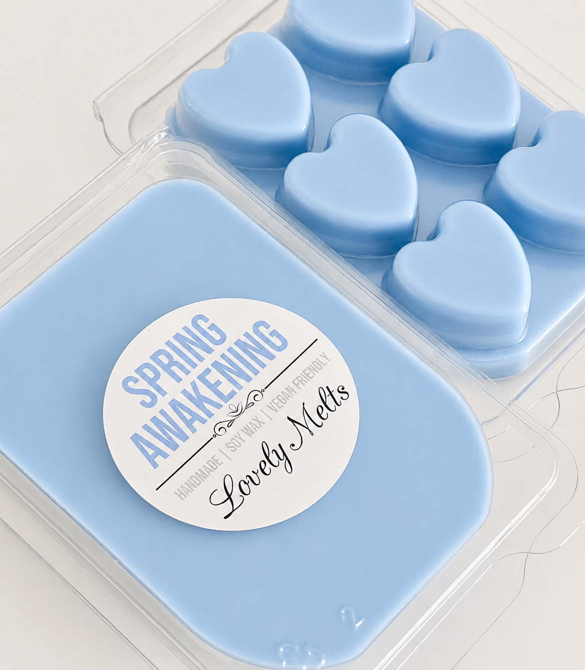 Blue heart-shaped wax melts in a mould with 'Spring Awakening' and 'Lovely Melts' label.