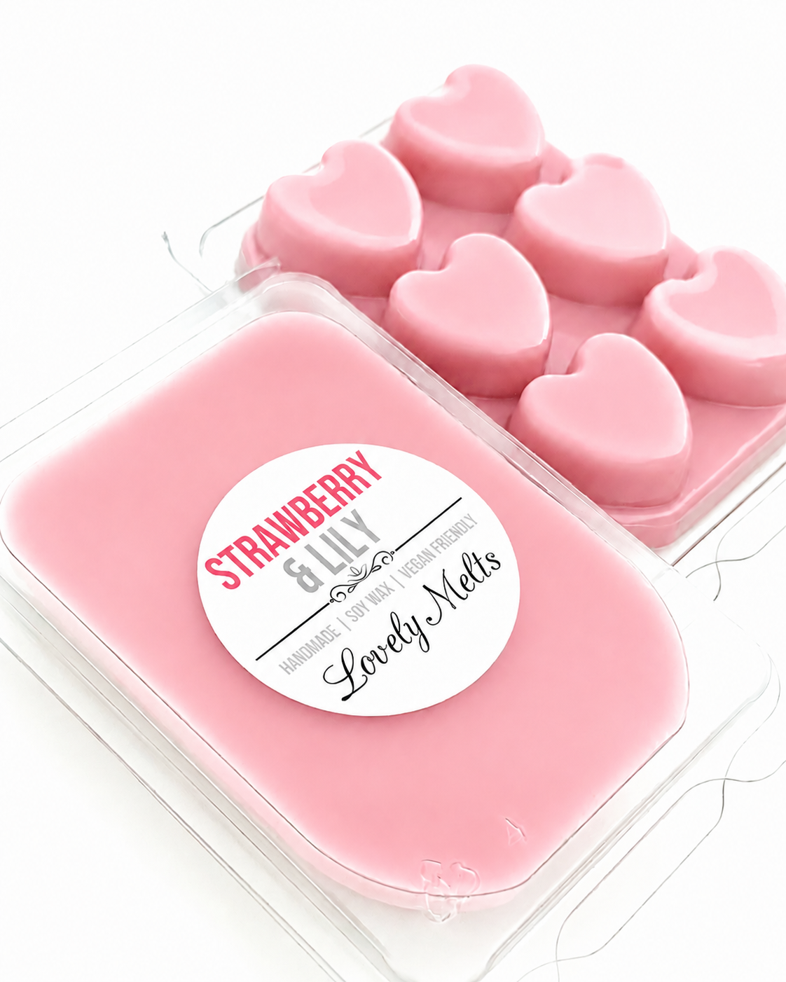 Pink heart-shaped wax melts in a container with 'Strawberry & Lily' label.