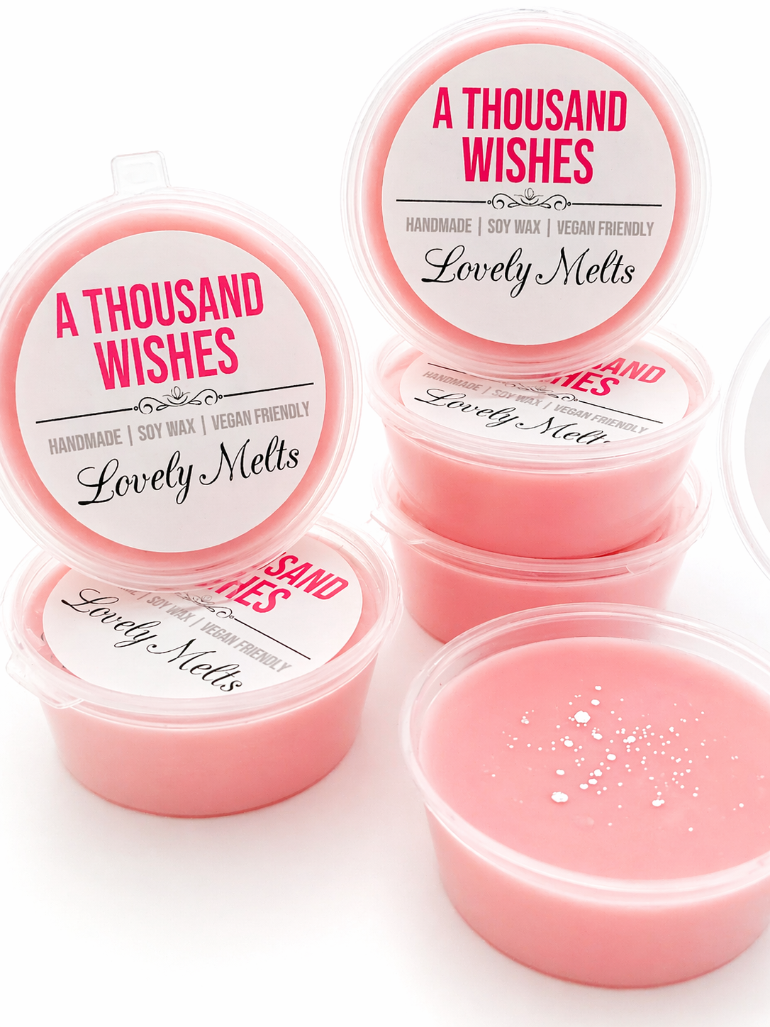 Pink wax melts in clear containers with 'A Thousand Wishes' and 'Lovely Melts' branding on a white background.