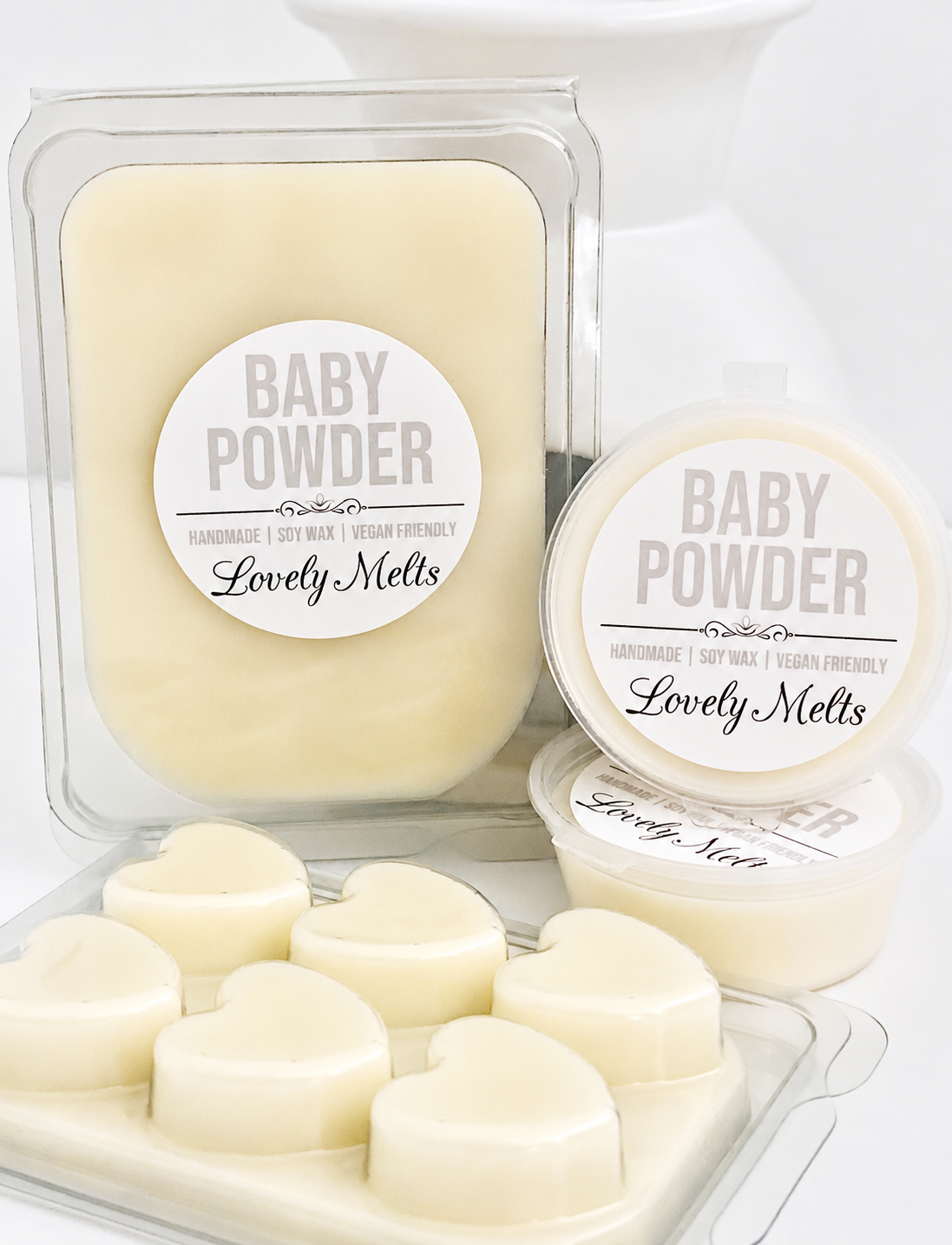 Heart-shaped wax melts in a clear container with 'Baby Powder' label, branded as 'Lovely Melts'.