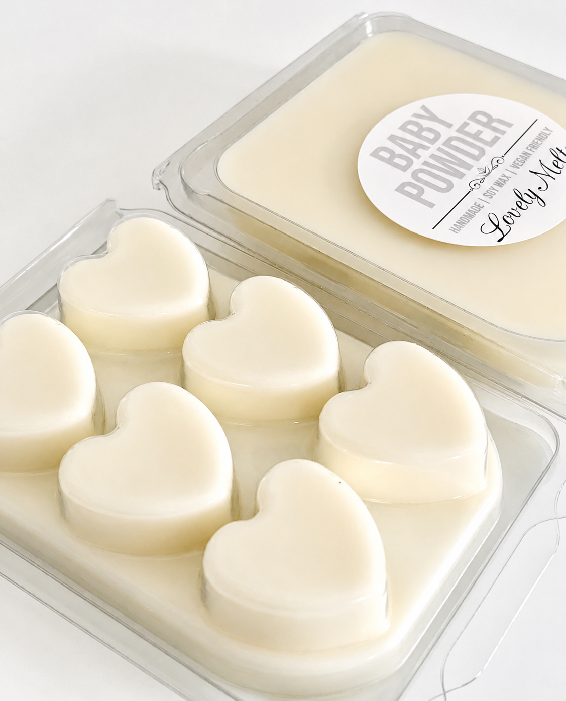 Heart-shaped soap bars in a clear container with a 'Baby Powder' label.