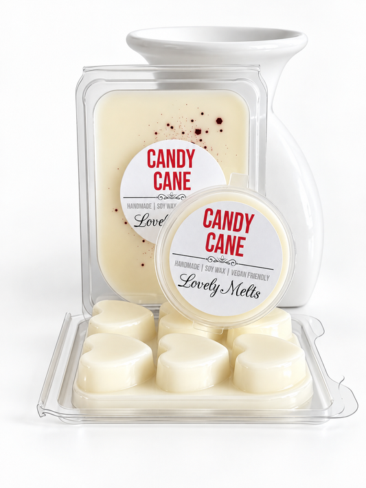 Lovely Melts 'Candy Cane' scented SOY wax melts on a white background, featuring a larger rectangular clamshell package with a round label and six heart-shaped wax melts in a clear CLAMSHELL in front, plus a smaller round pot with a matching lid behind it.