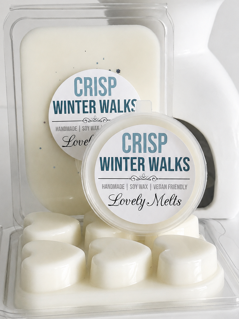 Cream-colored soy wax melts and wax blocks in clear plastic packaging with round labels reading 'CRISP WINTER WALKS' and 'Lovely Melts'.
