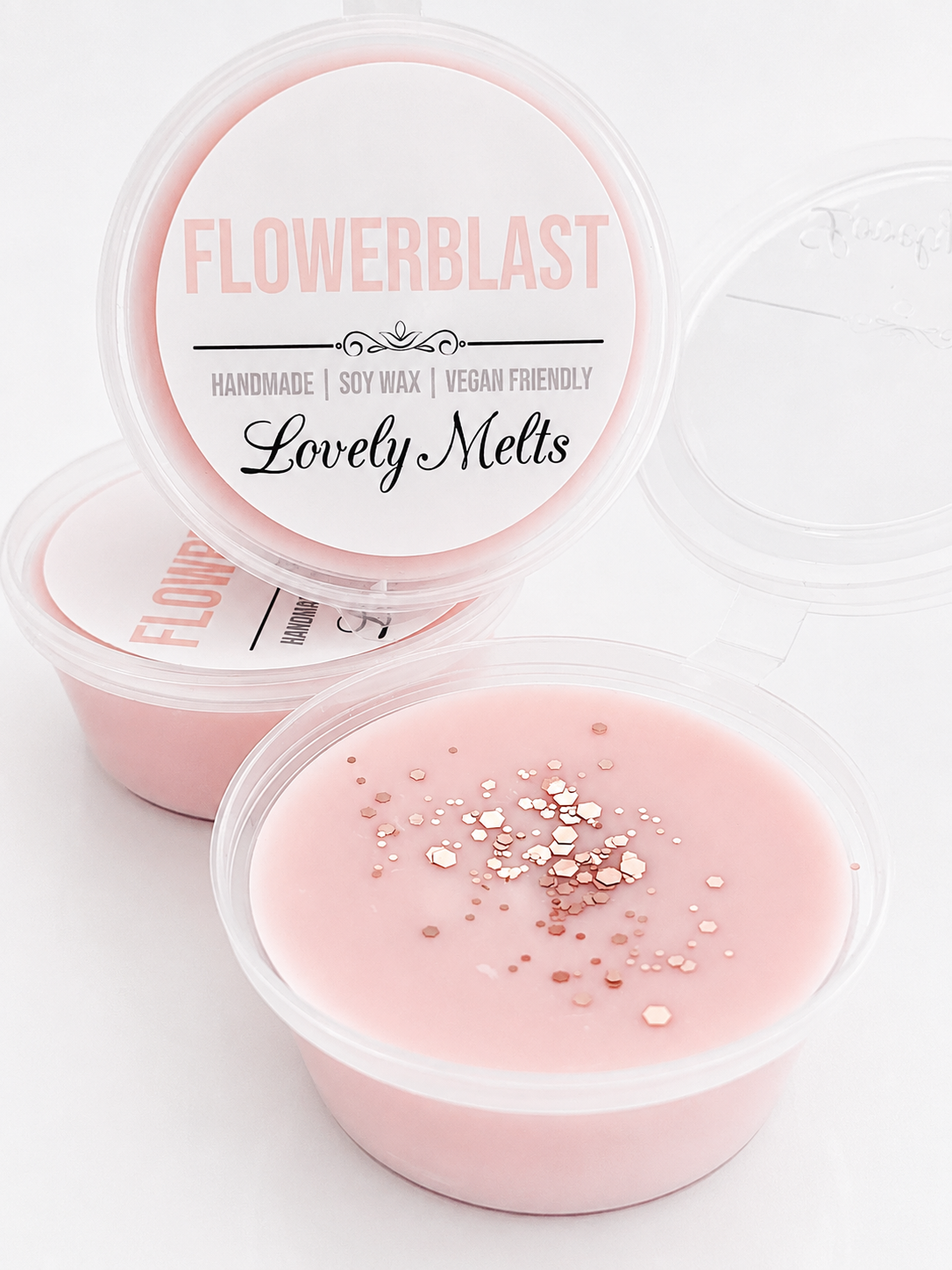 Pink wax melts in clear containers with 'Flowerblast' branding on a white background