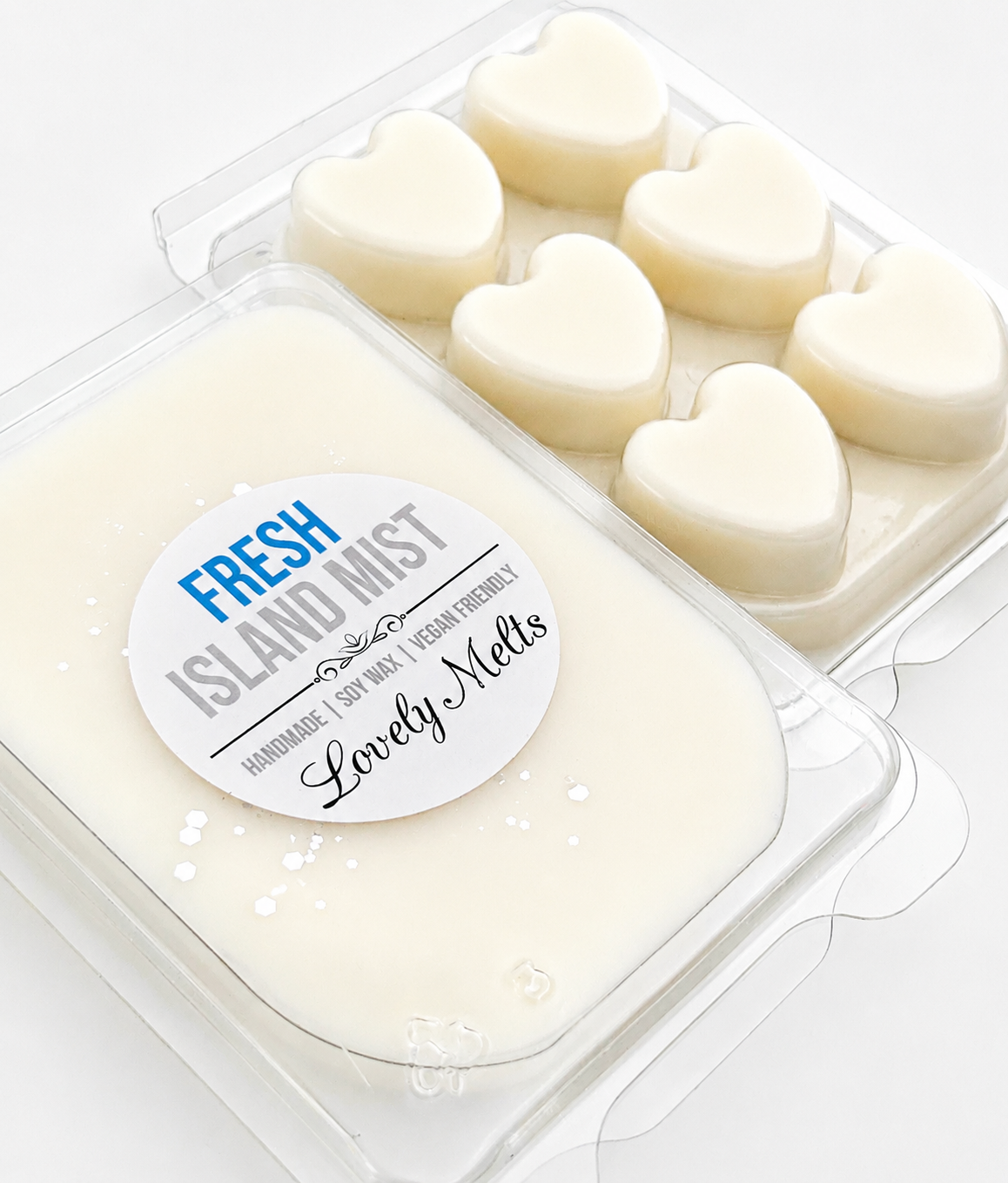 Heart-shaped wax melts in a clear container with a 'Fresh Island Mist' label.