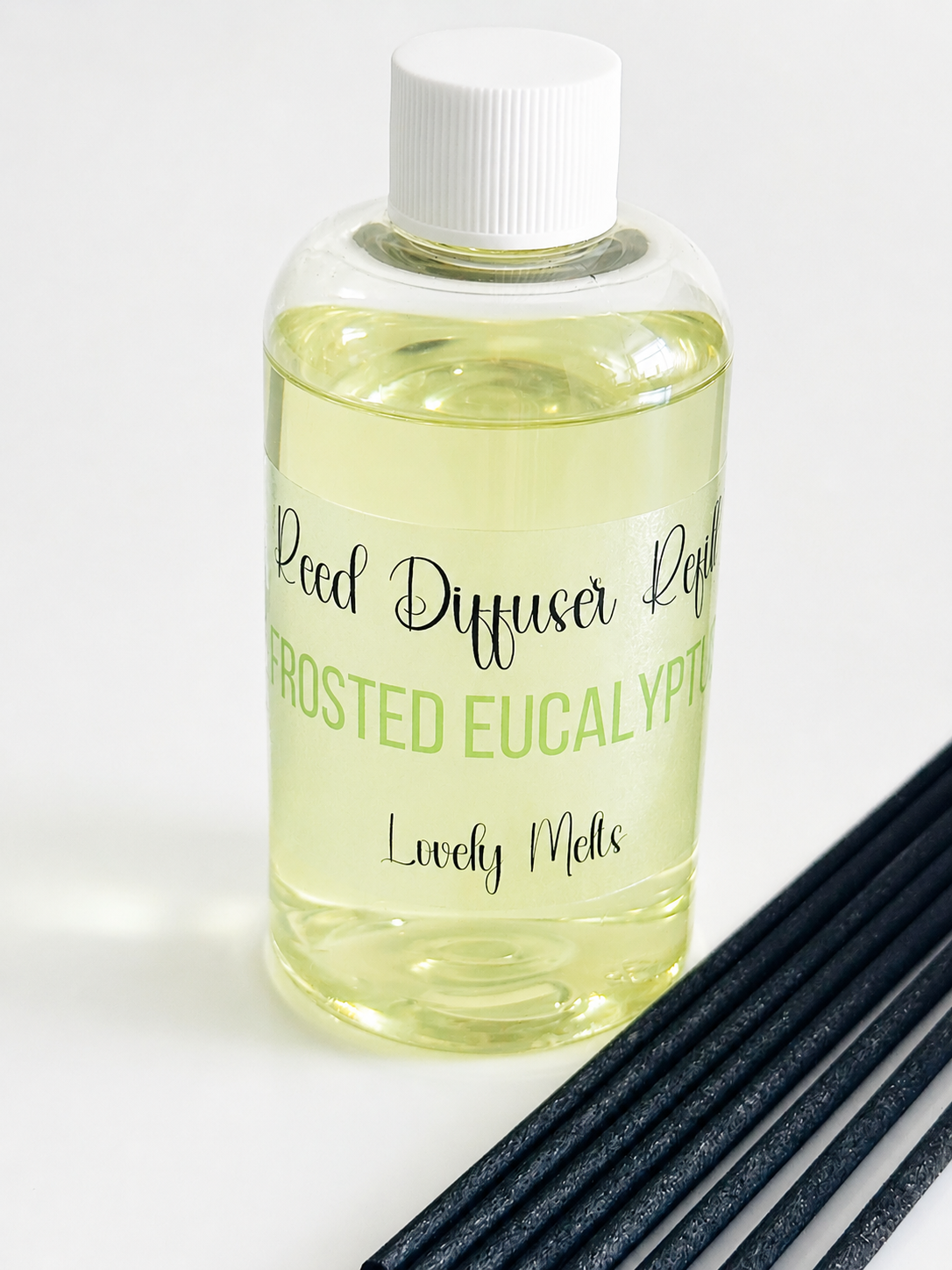 Bottle of Reed Diffuser Refill with 'Frosted Eucalyptus' label and black reeds on a white background