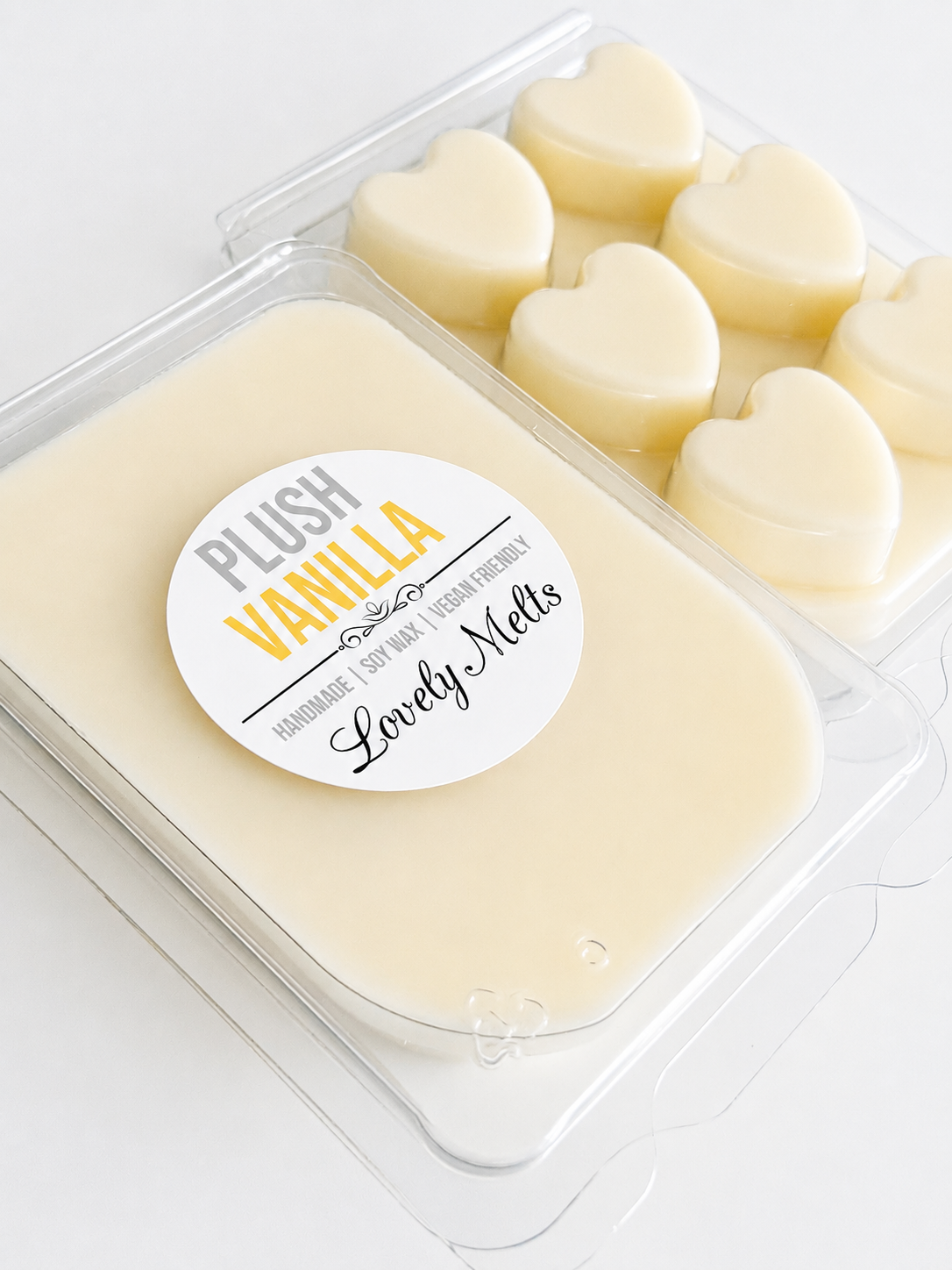 Heart-shaped vanilla wax melts in a clear container with a 'Plush Vanilla' label.