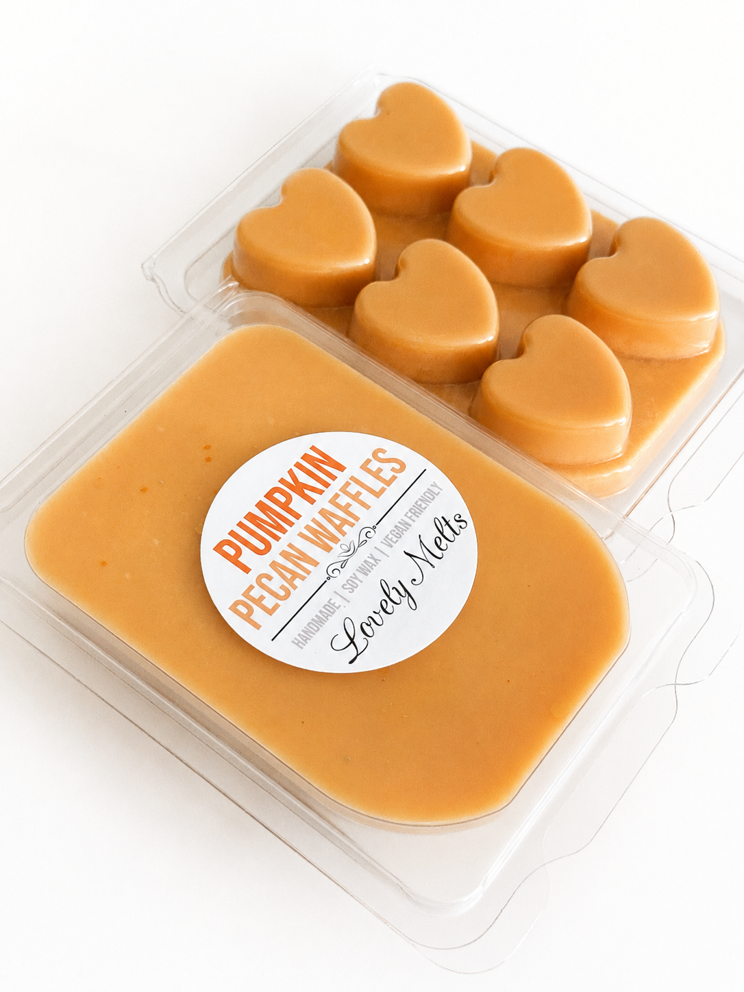 Pumpkin Pecan Waffles melts in a clear plastic clamshell container, with one rectangular wax melt in front showing a white label and six heart-shaped melts behind it.