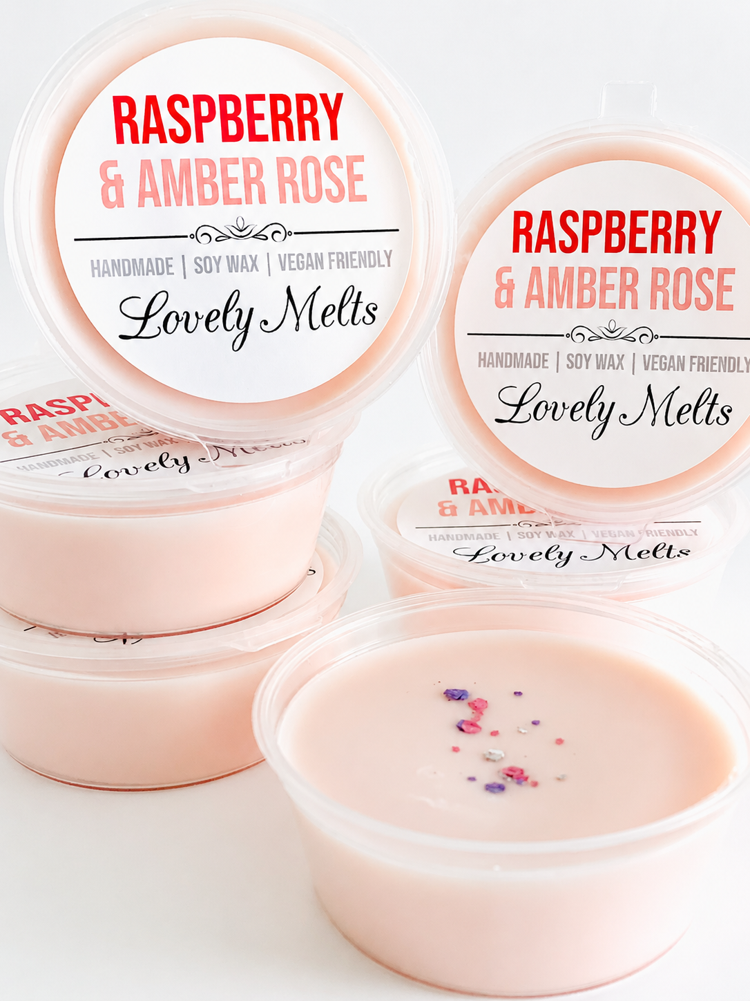 Three containers of Raspberry & Amber Rose scented wax melts on a white background