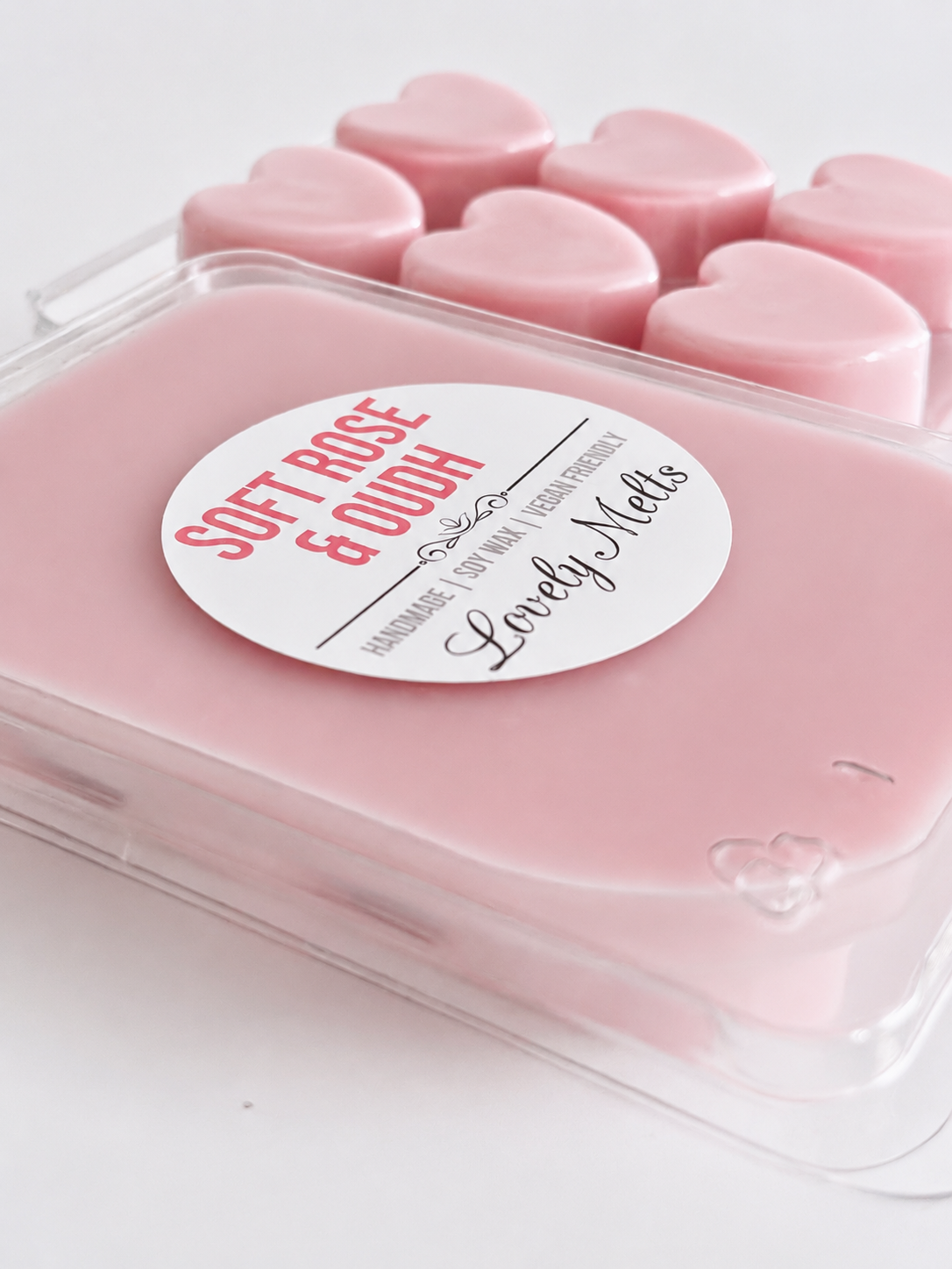 Pink heart-shaped wax melts in a container with a label on a white background