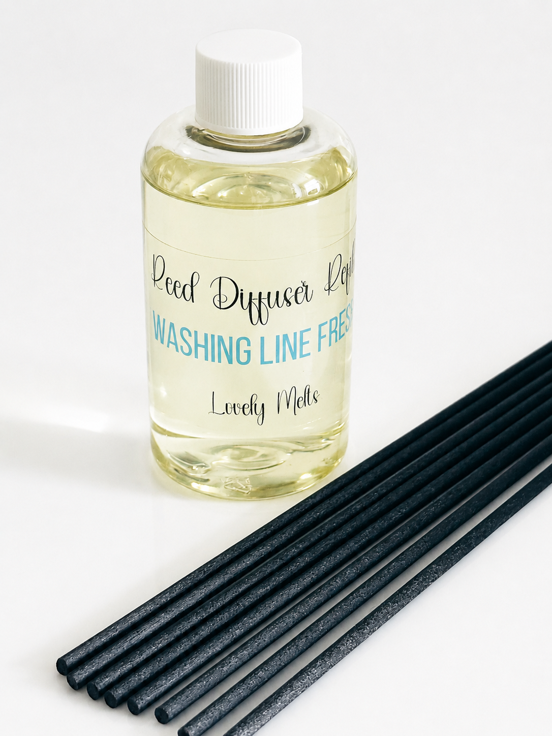 Bottle of Reed Diffuser Refill with black reeds on a white background