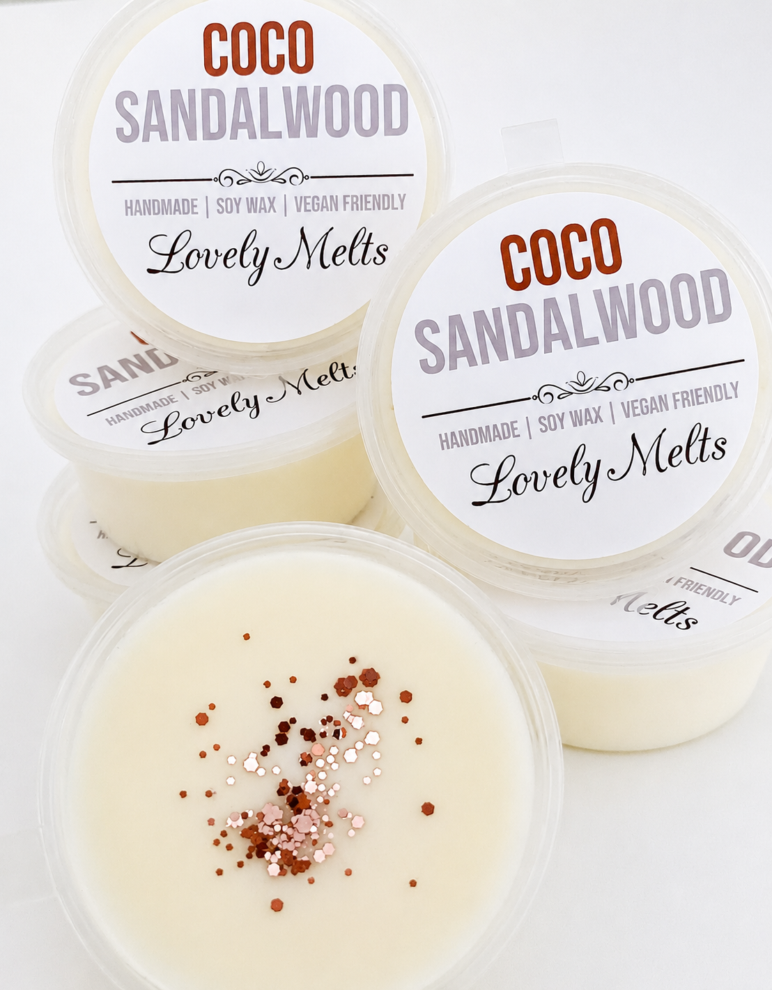 Coco Sandalwood scented wax melts with visible glitter on a white background