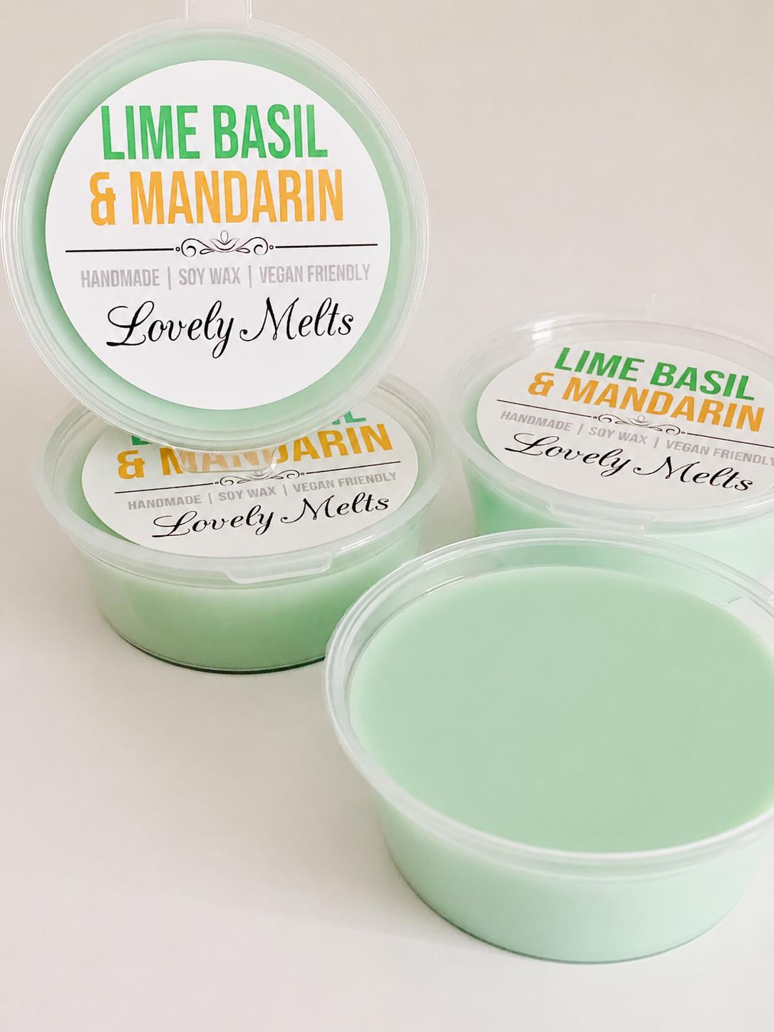 Green wax melts in containers with 'Lime Basil & Mandarin' label on a white background