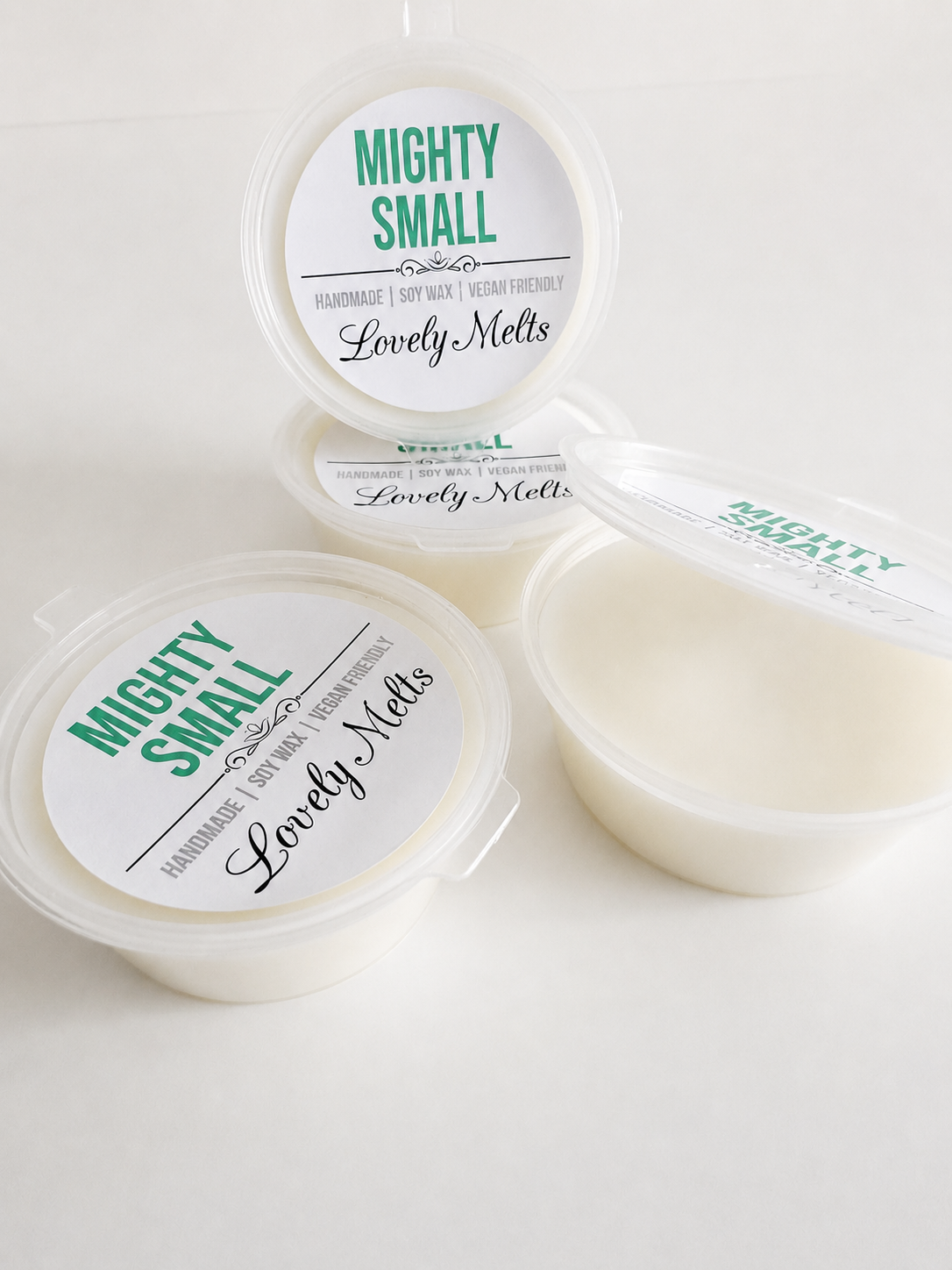 Three containers of 'Mighty Small' wax melts and 'Lovely Melts' on a white background