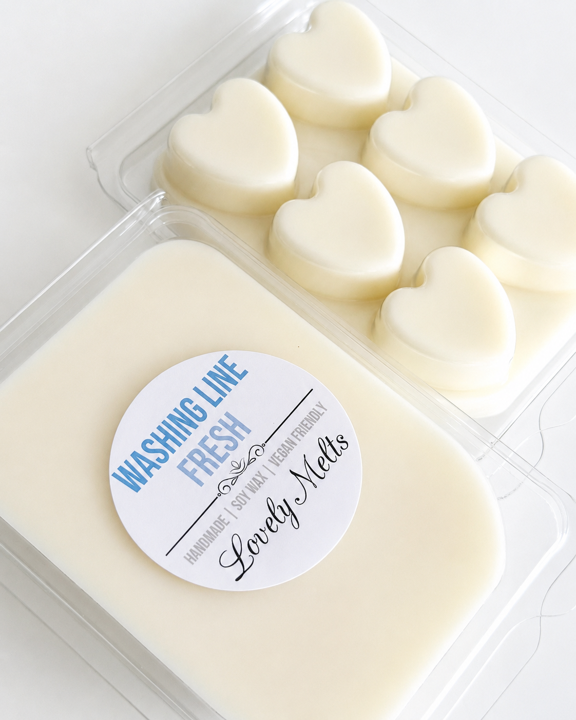 Heart-shaped wax melts in a container with a 'Lovely Melts' label  washing line fresh